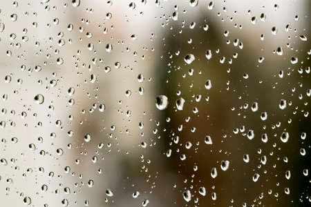 Rain drops on window glasses surface with cloudy background. Natural Pattern of raindrops isolated...