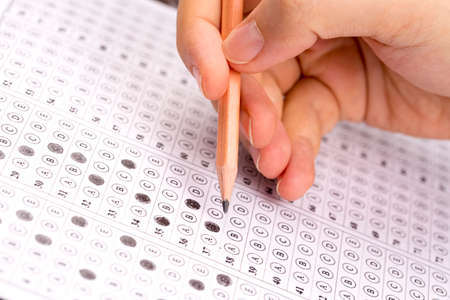 Standardized test form with answers bubbled in and a pencilの写真素材
