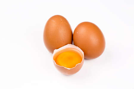 Many eggs lie on the background of hay, top view.