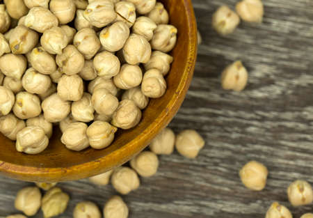 Dry chickpeas close up in a wooden spoon on a backgroun