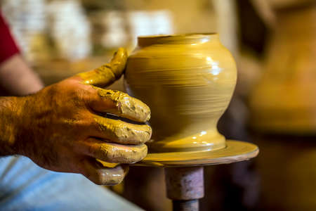 Professional potter making bowl in pottery workshop, studio.の写真素材
