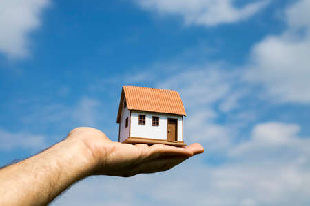 Dwelling environment, small model house and blue sky. House image.の写真素材