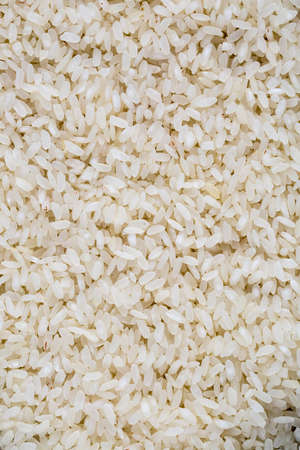 Top view of a heap of raw parboiled rice isolated on white background. Healthy food. Close up, high...