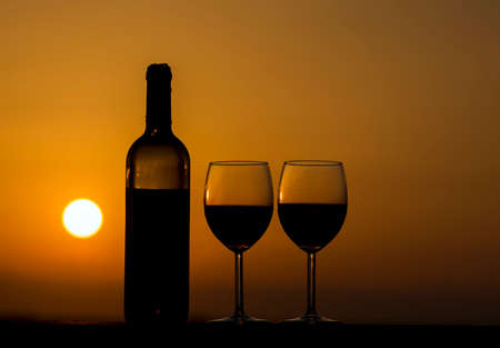 Pair of red wine glasses on the beach.の写真素材