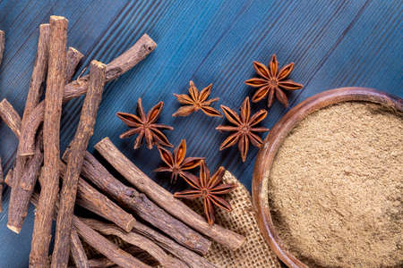 Star anise, cinnamon sticks and powder on a blue wooden backgroundの写真素材