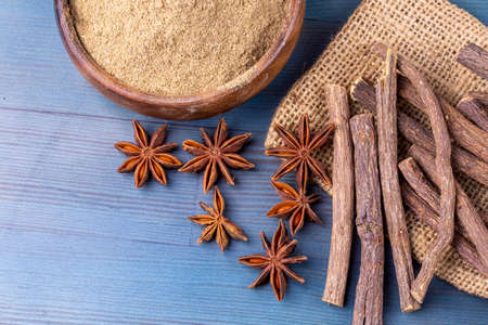 Cinnamon sticks, anise stars and cinnamon powder on wooden backgroundの写真素材