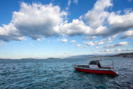 Fishing boat in the sea on a background of blue sky with cloudsの写真素材