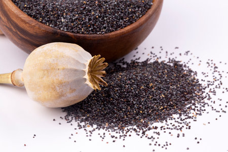 Poppy seeds in wooden bowl on white background. Selective focus.の写真素材