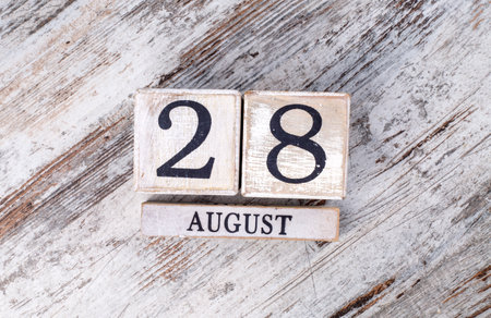 Wooden cube calendar with August 28 date on white wooden background.の写真素材