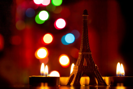 Eiffel tower and burning candles in front of bokeh backgroundの写真素材