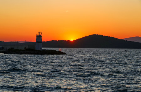 Sunset on the Adriatic Sea with a lighthouse in the foregroundの写真素材