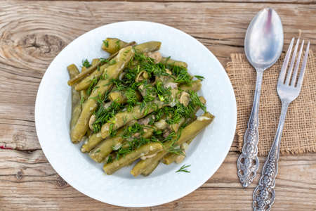 Green beans with parsley and dill on a wooden background.の写真素材
