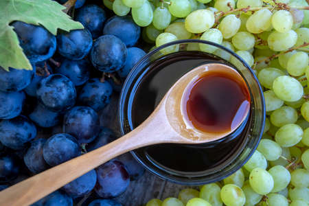 Grape molasses and fresh organic grapesの写真素材
