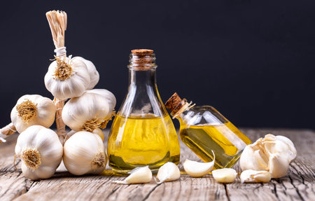 Garlic and garlic oil on a wooden background. Selective focus.の写真素材