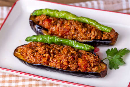 Stuffed eggplant with minced meat and vegetables on wooden background.の写真素材