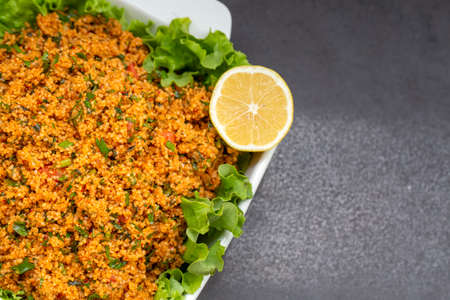 Couscous salad with parsley and lemon on a black backgroundの写真素材
