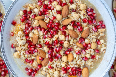 Oatmeal with nuts and pomegranate seeds in a metal plateの写真素材