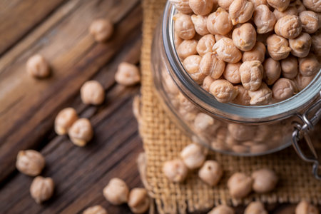 Raw chickpeas in a glass jar on a wooden background.の写真素材
