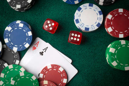 Playing cards, dice and poker chips from above on the green poker table