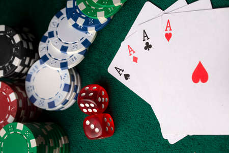 Playing cards, dice and poker chips from above on the green poker table
