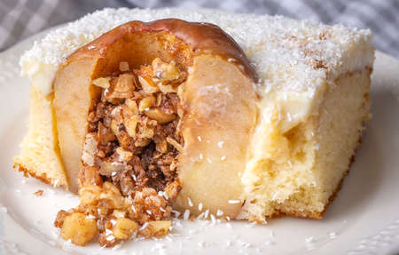 Baked apple with cinnamon and nuts on a white plate close upの写真素材