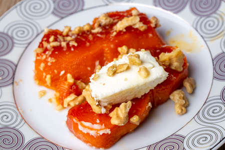 Honey cake with walnuts on a white plate, close-upの写真素材