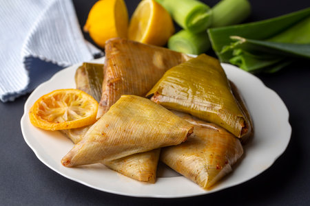 Sticky rice wrapped in banana leaves and served with lemons.の写真素材