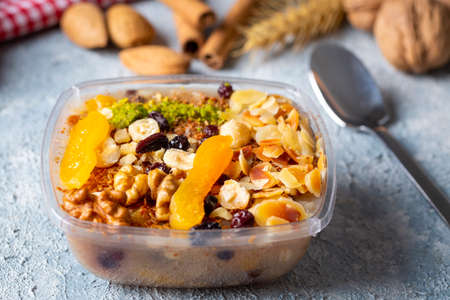 Healthy breakfast bowl with oatmeal, nuts, raisins and dried fruits