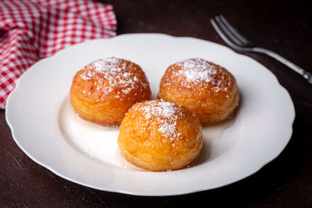 Buns with powdered sugar on a white plate.の写真素材