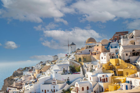 Beautiful view of Oia with traditional white houses and windmills in village, Santorini island, Greeceの写真素材