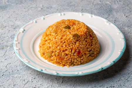 Traditional turkish bulgur pilaf with tomato sause in plate (Turkish name; meyhane pilaf)の写真素材