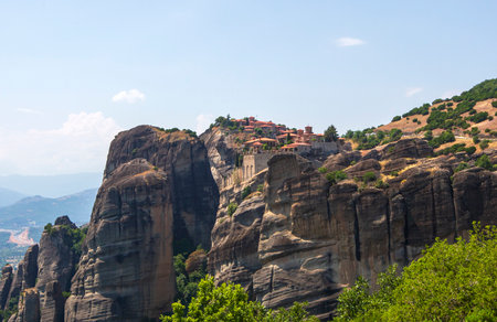 Aerial view of Meteora, Greece, featuring ancient monasteries atop towering rocks under a dramatic...