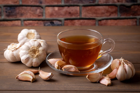 Cup of healthy garlic tea on tableの写真素材