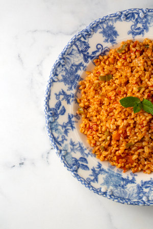 Traditional turkish bulgur pilaf with tomato sause in plate (Turkish name; meyhane pilaf)の写真素材