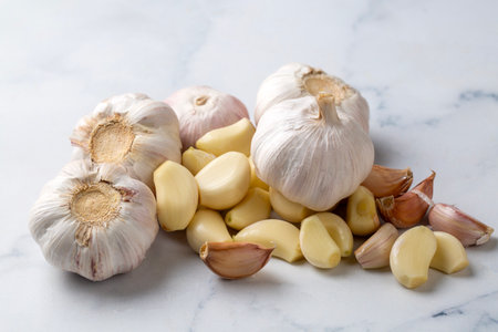 Garlic cloves in a glass bowl with peeled garlicの写真素材