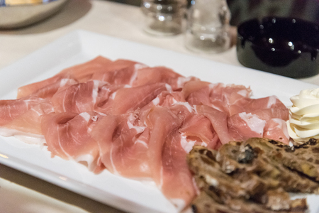 Prosciutto antipasto served in a restaurant in Italyの写真素材