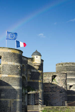 Towers of castle of Angers under rainbow, France and EU bannersのeditorial素材