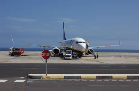 TENERIFE, SPAIN - JULY 16, 2014: Ryanair plane is refueling near ocean to on July 16, 2014 in Tenerife. Ryanair is biggest budget lowcost airline in the world.のeditorial素材