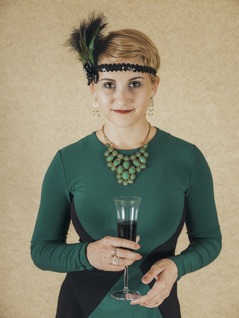 The girl dressed in the fashion of Chicago 30s with the glass of wineの写真素材
