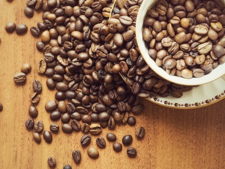 Cup with saucer and coffee beans on the tableの写真素材