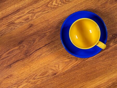 Top view on the cup with saucer, standing on the wooden tableの写真素材