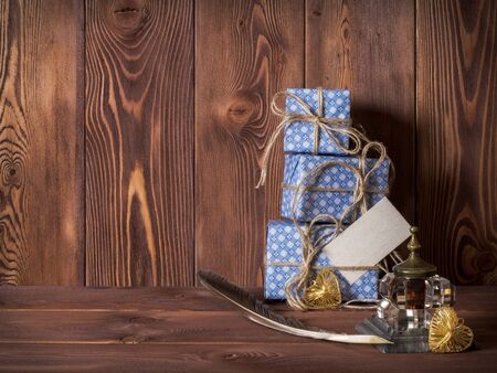 Gift boxes, feather and inkstand on the table. Side viewの写真素材