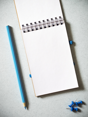 Notebook, pencil and some pins on the table. Top viewの写真素材