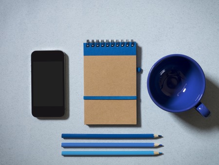 Notebook, pencils, mobile phone and tea cup on the table. Top viewの写真素材