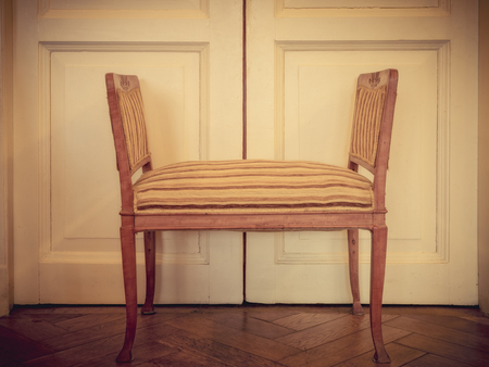Old banquette on the wooden floor. Pastel color