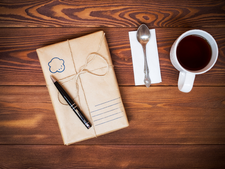 Gift wrapped in paper with place for the customer text and cup of tea. View from aboveの写真素材