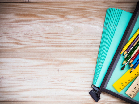 Pile of notebooks and school supplies on the wooden background. School conceptの写真素材