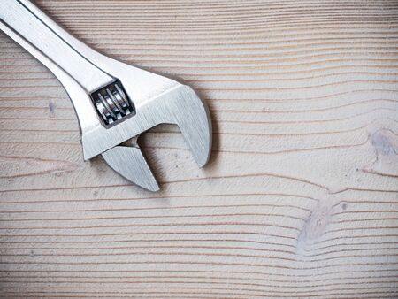Adjustable wrench on wooden background. Copy space. Construction conceptの写真素材