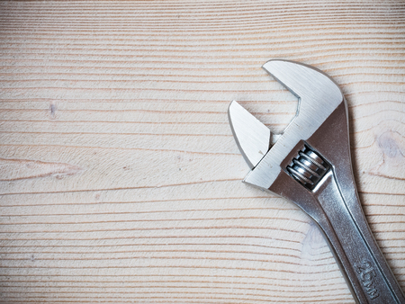 Stainless adjustable spanner on wooden board. Copy space. Plumbing conceptの写真素材