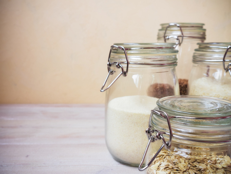 Cereals and grains in glass jars standing on the tableの写真素材